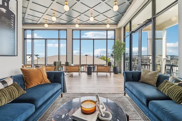 a living room with furniture and a floor to ceiling window