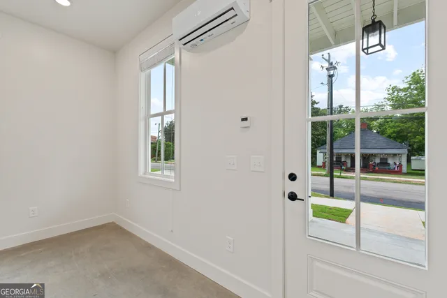 an empty room with windows and ceiling fan