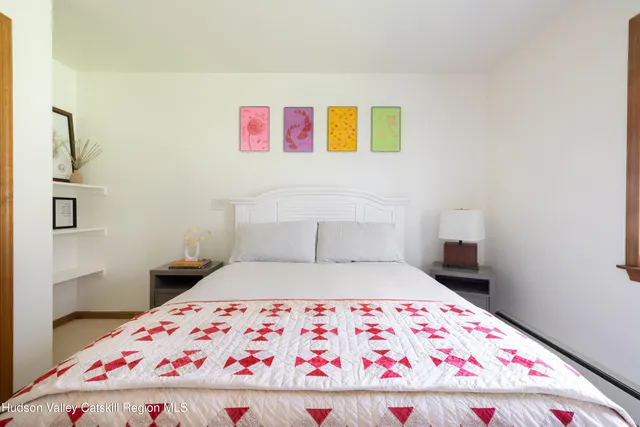 a bedroom with a bed and a painting on the wall