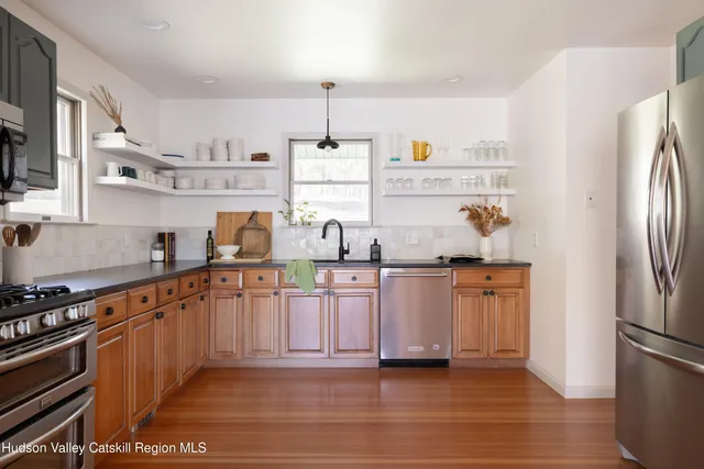 a kitchen with stainless steel appliances granite countertop a refrigerator and a stove top oven