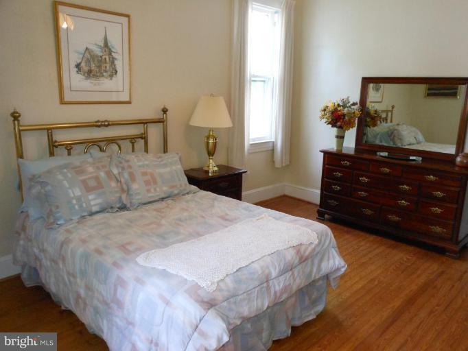 616 North Bend Road Baltimore, MD 21229 - Photo 13 of 18 a bedroom with a bed and a mirror on dresser