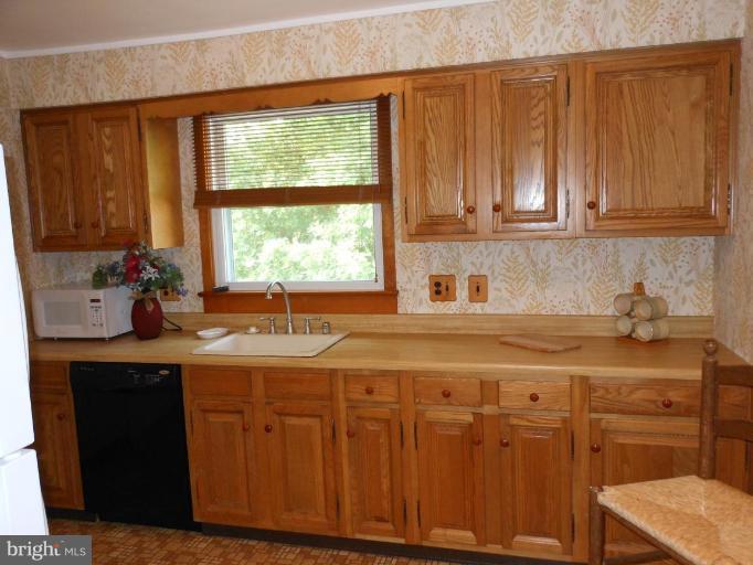 616 North Bend Road Baltimore, MD 21229 - Photo 4 of 18 a kitchen with stainless steel appliances granite countertop a sink window and cabinets