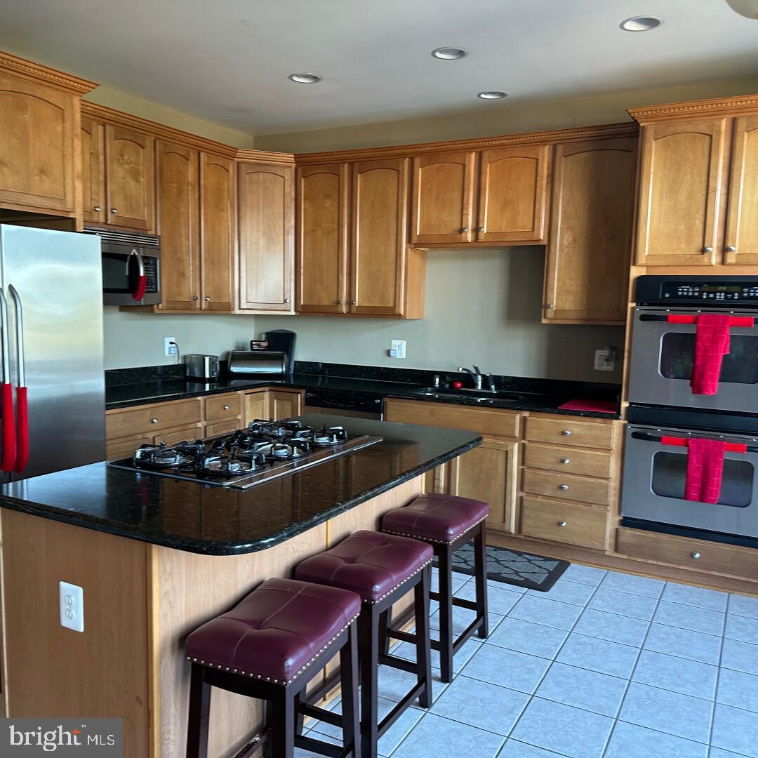 17696 Possum Point Road Dumfries, VA 22026 - Photo 28 of 45 a kitchen with stainless steel appliances granite countertop a stove a sink and a refrigerator
