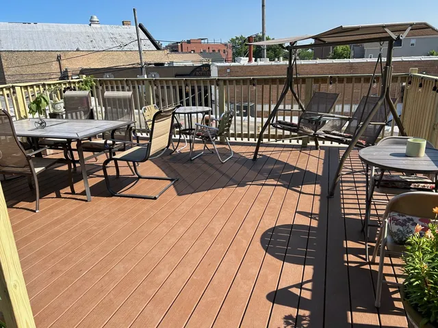 a view of a roof deck with table and chairs with wooden floor