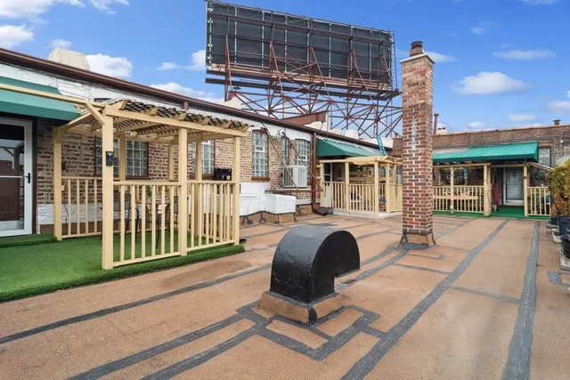 a front view of a house with barbeque grill and outdoor seating