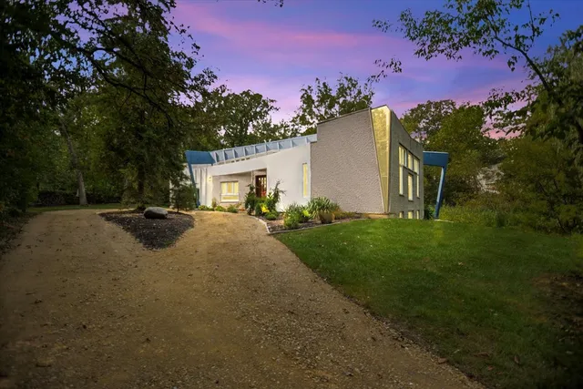 a view of a white house with a yard and a garden