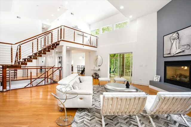 a living room with fireplace furniture and a view of kitchen