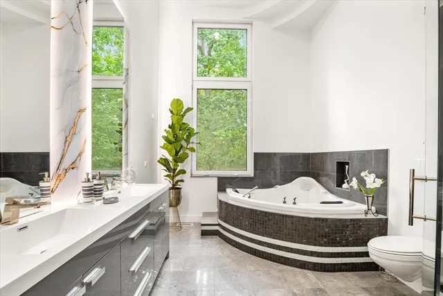a bathroom with a double vanity sink toilet and a mirror