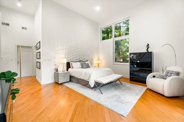 a bedroom with a bed and wooden floor