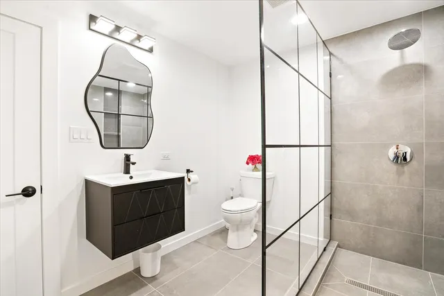 a bathroom with a sink a large mirror and a toilet