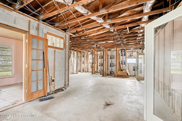 a view of a bedroom with a bed and wooden floor