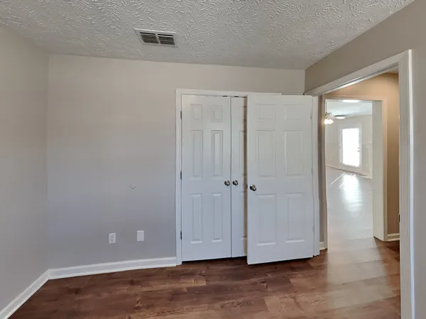a view of room with hardwood floor and closet area