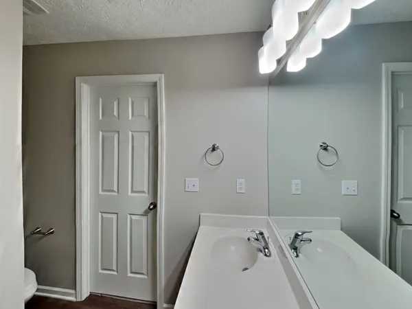 a bathroom with a tub sink and mirror