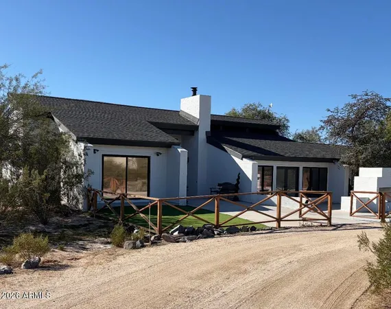 a backyard of a house with table and chairs