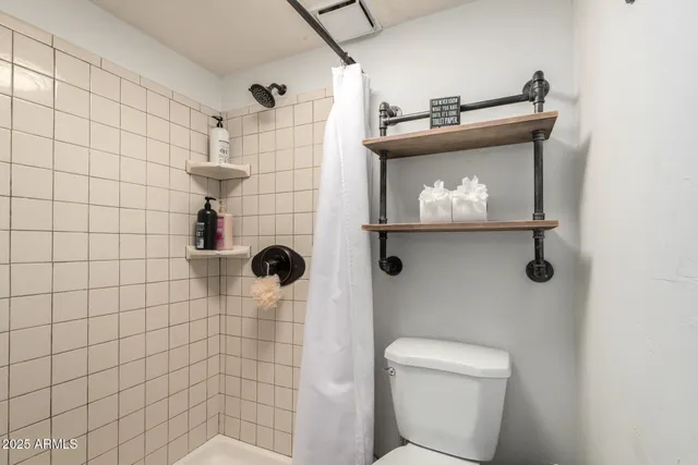 a bathroom with a toilet and a shower