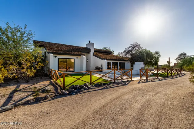 a view of a house with backyard and sitting area