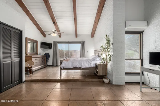 a spacious bedroom with a bed and a large mirror