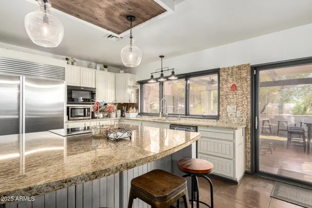 a kitchen with granite countertop a counter space a sink appliances and cabinets