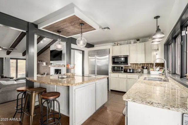 a kitchen with a sink stainless steel appliances and white cabinets