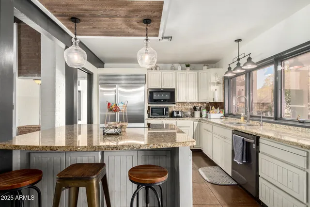 a kitchen with stainless steel appliances granite countertop a stove a sink and a refrigerator