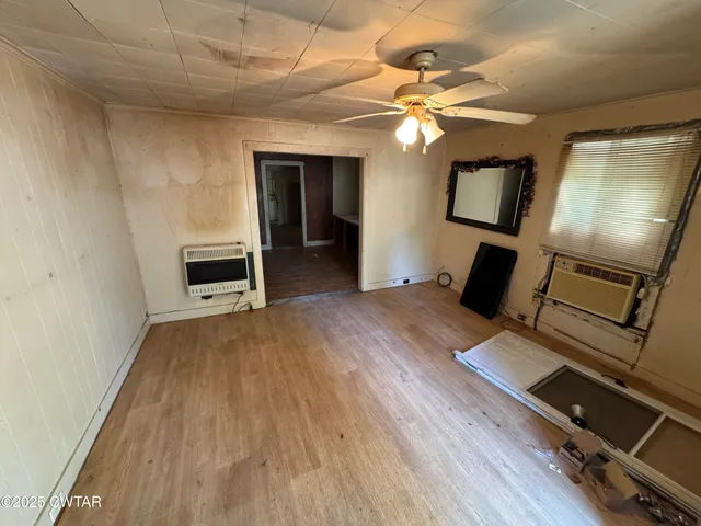 a view of a livingroom with wooden floor and a ceiling fan