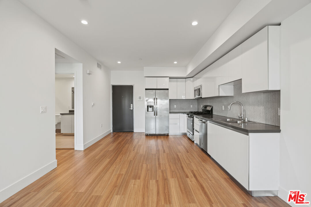 518 North Gramercy Place, Unit PH1 Los Angeles, CA 90004 - Photo 7 of 13 a kitchen with stainless steel appliances granite countertop a refrigerator and a stove top oven