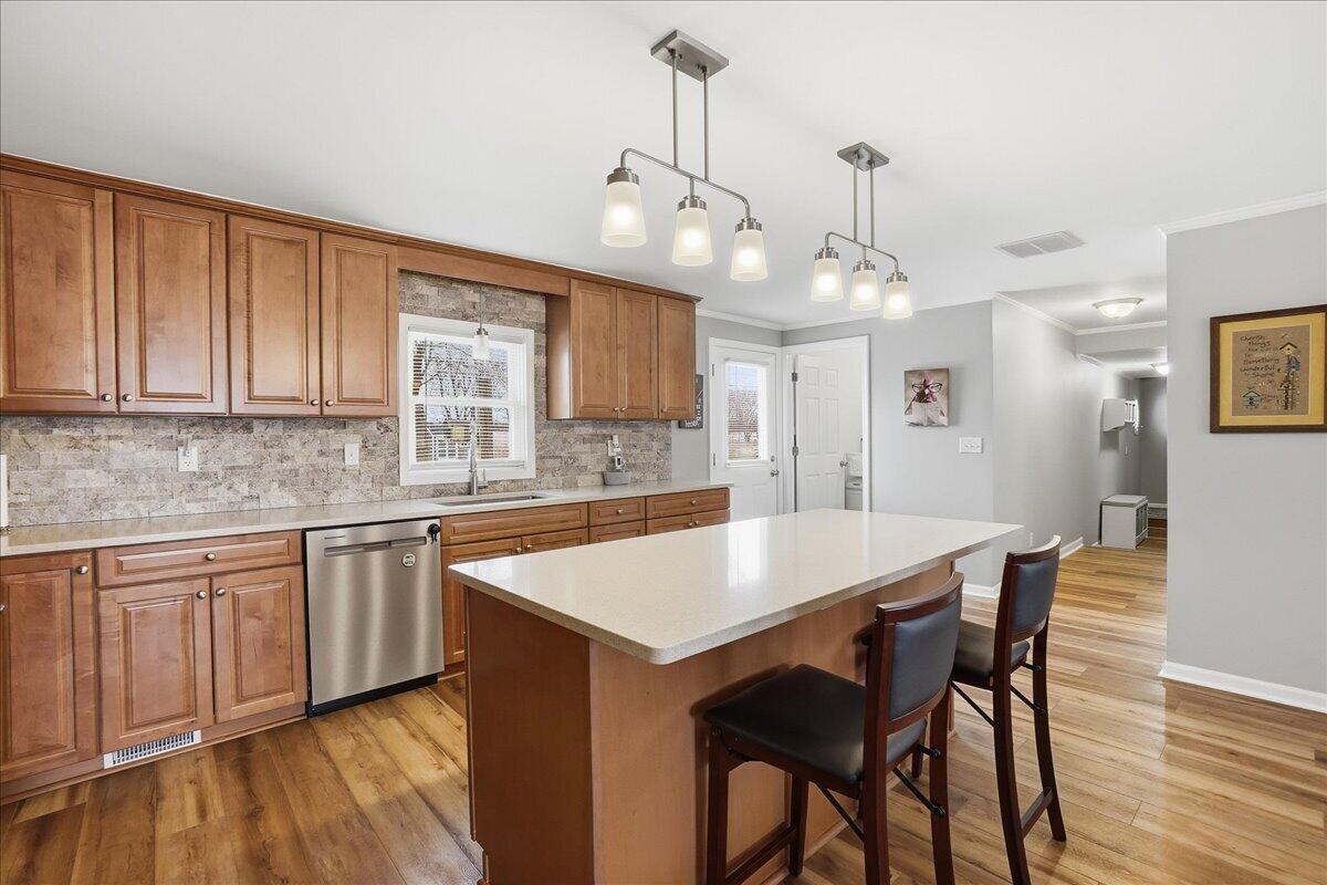 18311 Clark Street Lowell, IN 46356 - Photo 13 of 36 a large kitchen with kitchen island a dining table chairs and white cabinets