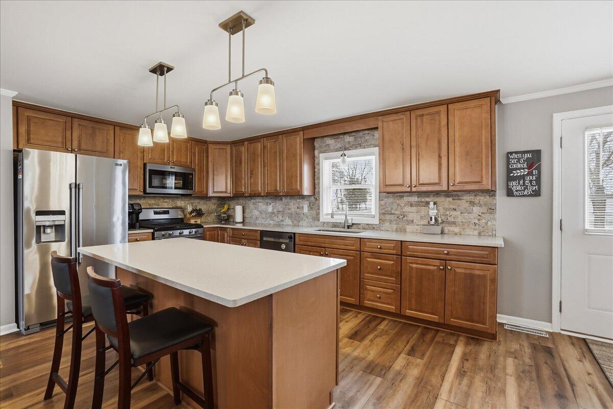 18311 Clark Street Lowell, IN 46356 - Photo 14 of 36 a kitchen with granite countertop a center island a sink cabinets and stainless steel appliances