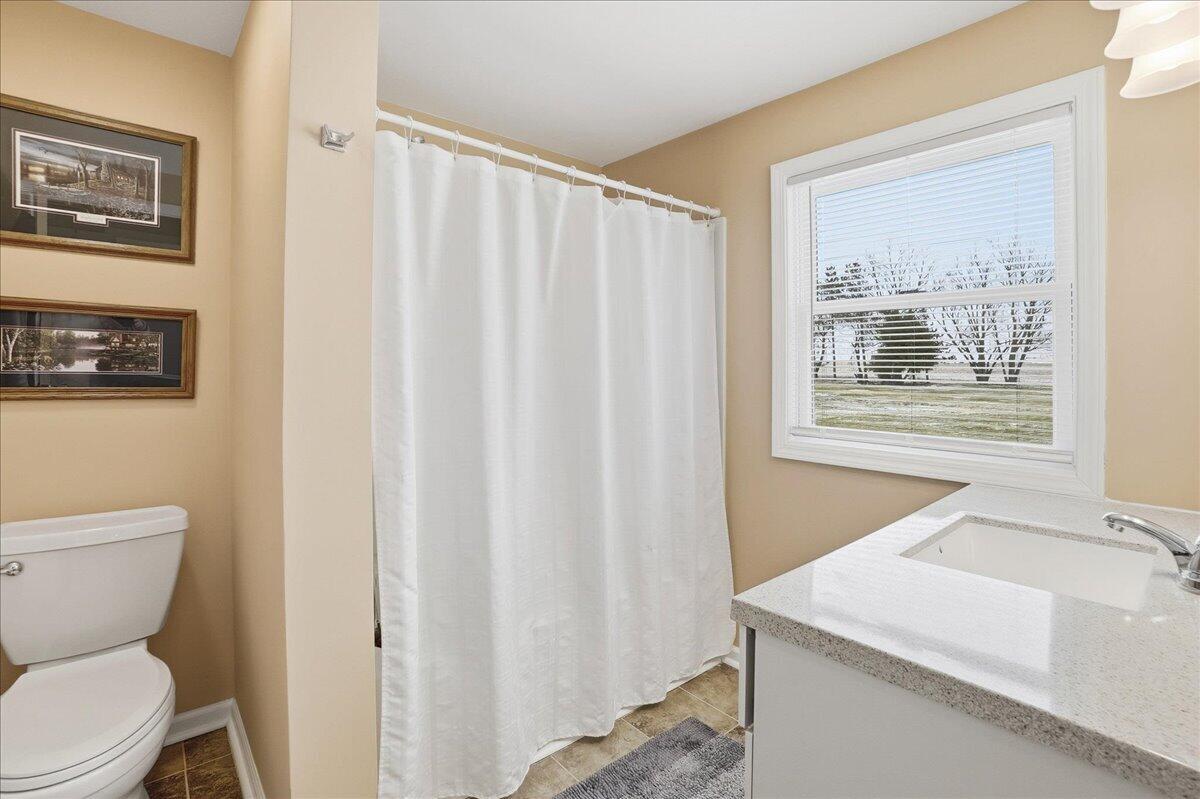 18311 Clark Street Lowell, IN 46356 - Photo 18 of 36 a bathroom with a toilet a sink and a window