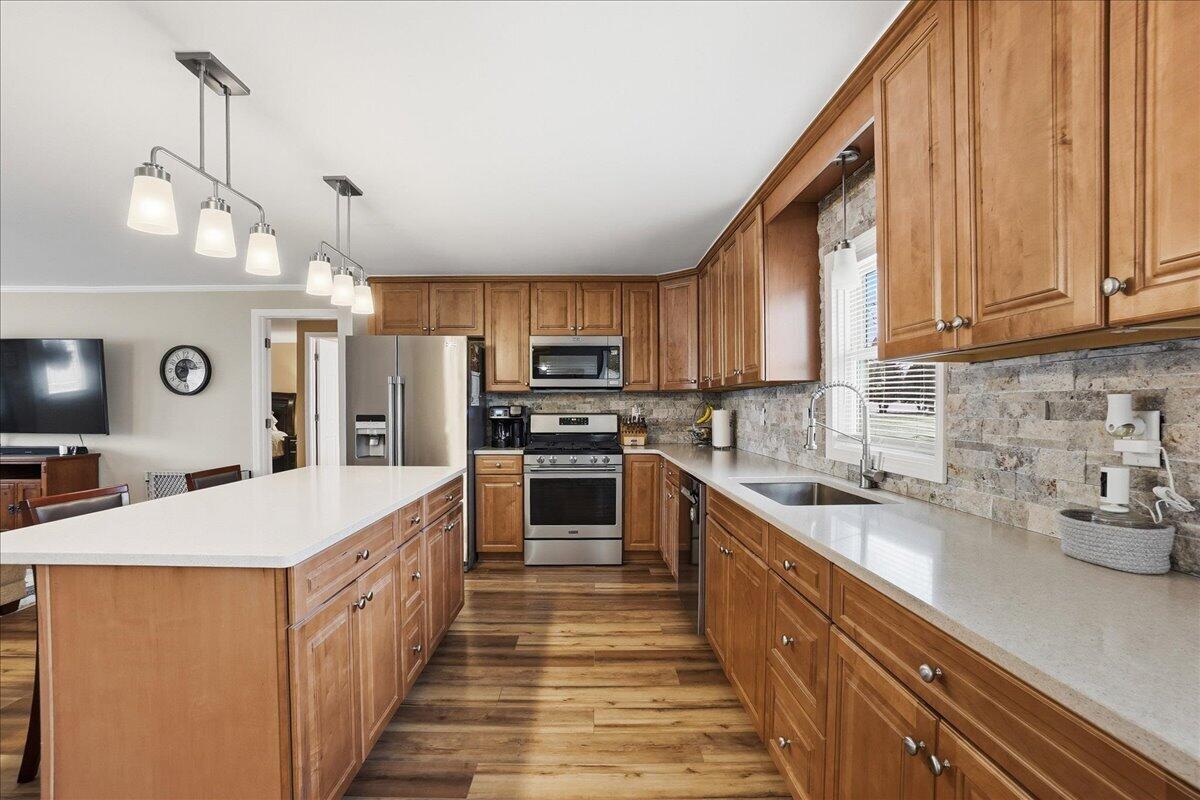 18311 Clark Street Lowell, IN 46356 - Photo 10 of 36 a large kitchen with stainless steel appliances granite countertop a sink counter space cabinets and a wooden floor