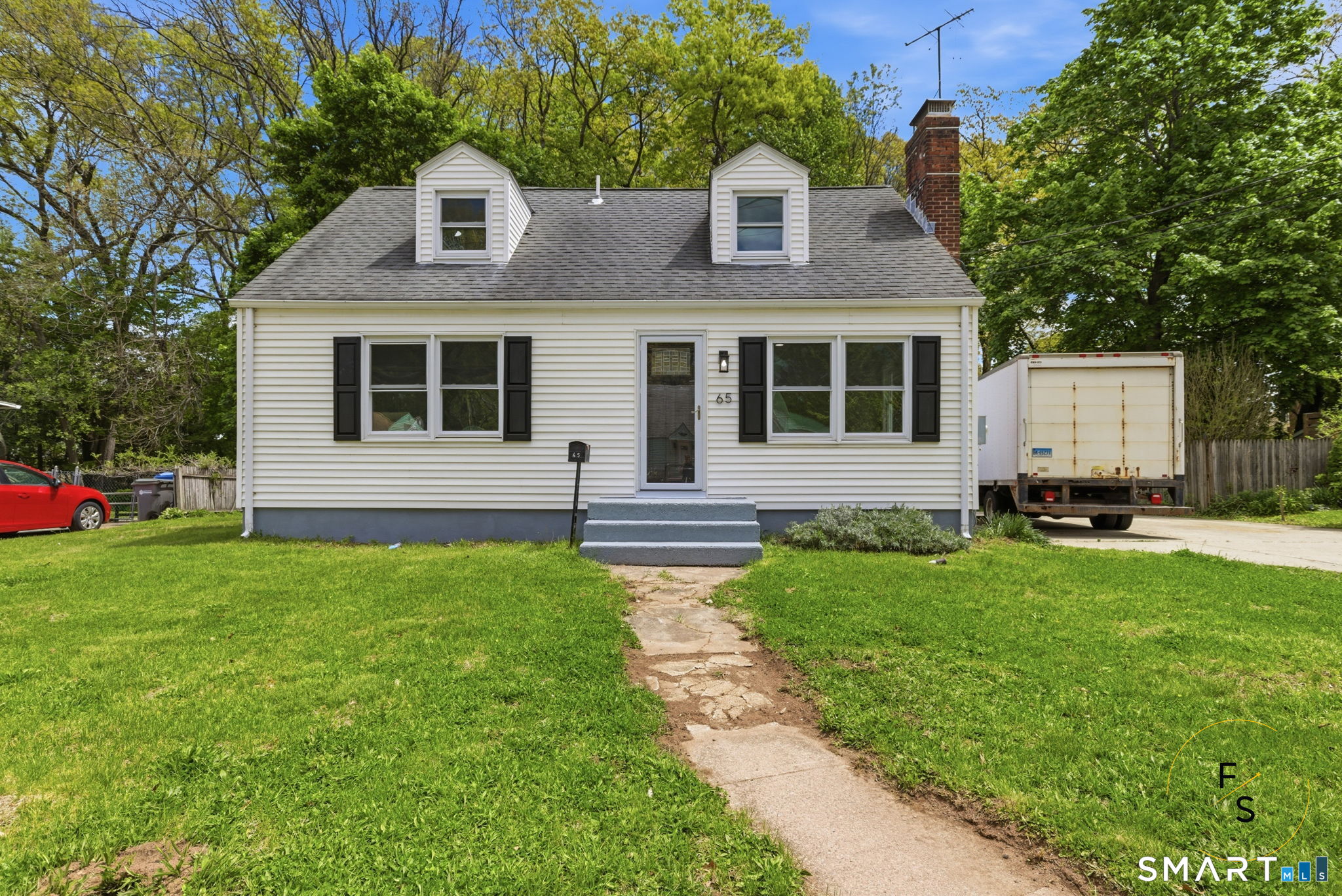 65 Broad Street Manchester, CT 06042 - Photo 1 of 40 a front view of a house with a garden and trees