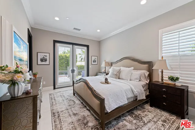 a bedroom with a bed potted plant on dresser and a window