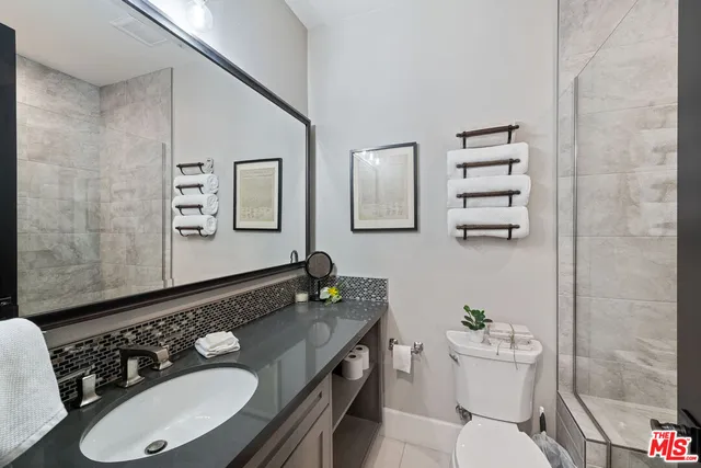 a bathroom with a granite countertop sink mirror vanity and toilet