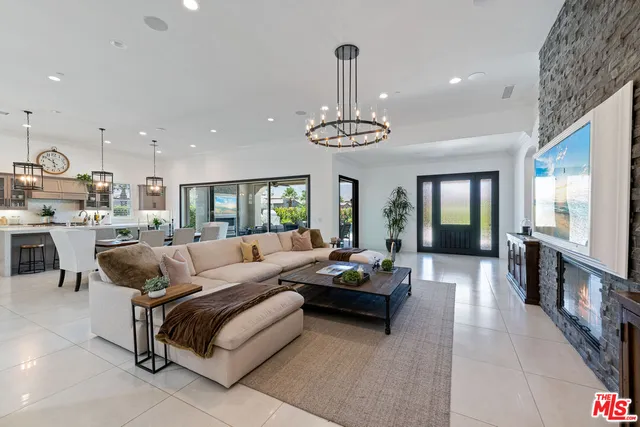 a living room with furniture kitchen and a chandelier