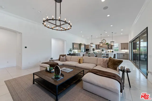 a living room with furniture kitchen view and a table