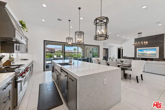 a kitchen with stainless steel appliances granite countertop a sink a stove and a wooden floors