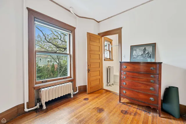 a view of a bedroom with wooden floor and cabinet