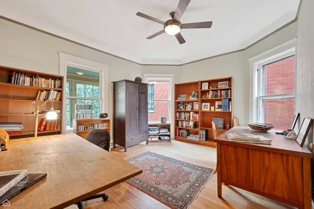 a living room with furniture a bookshelf and a window