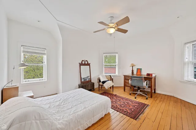 a bedroom with a bed and wooden floor