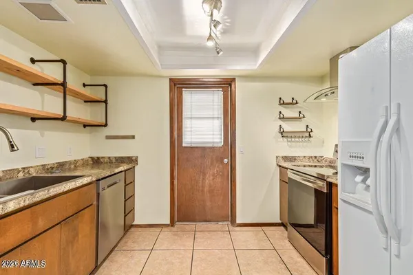 a kitchen with stainless steel appliances granite countertop a refrigerator and a stove top oven