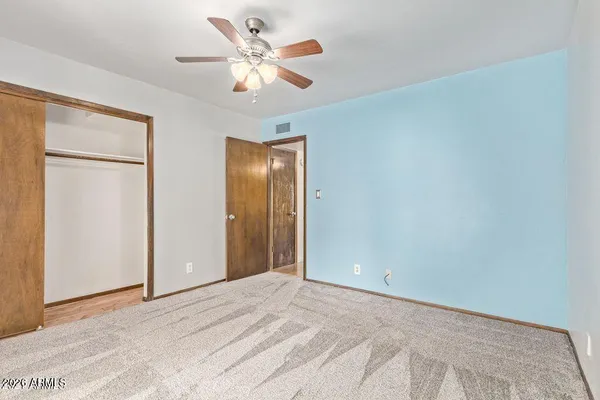 a view of a big room with closet and a chandelier fan
