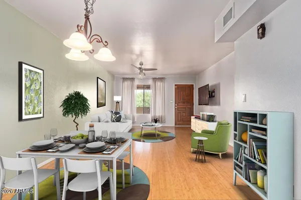 a view of a dining room with furniture a rug and wooden floor