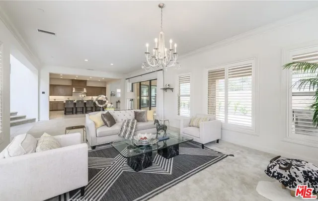 a living room with furniture chandelier and a large window