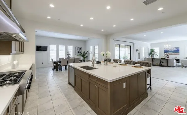 a large kitchen with stainless steel appliances a sink and a stove
