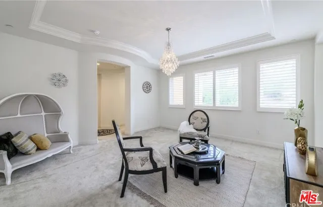 a bed sitting in a bedroom next to a window and a chair