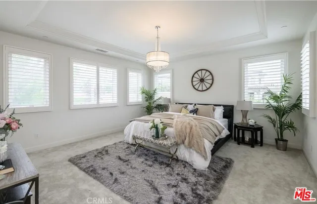 a spacious bedroom with a bed and a flat screen tv