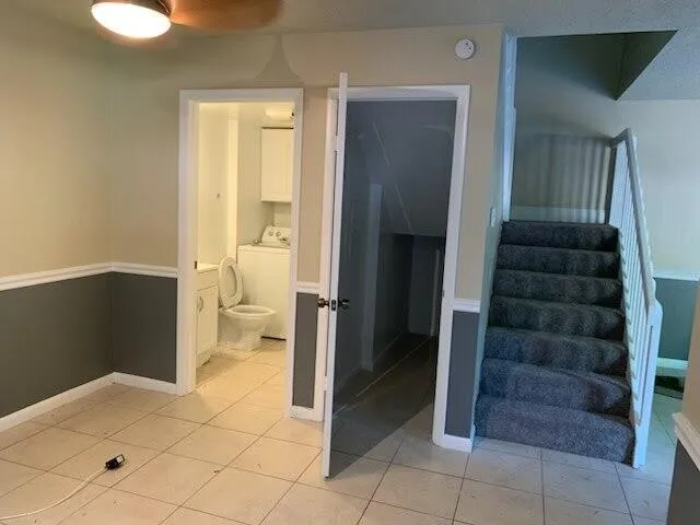 a view of a hallway with wooden floor and a living room