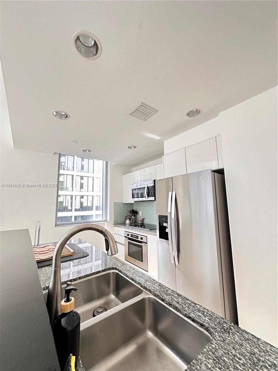 1060 Brickell Avenue, Unit 413 Miami, FL 33131 - Photo 4 of 13 a close view of a sink a refrigerator and window