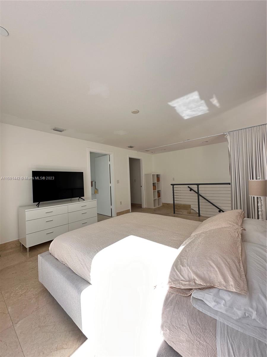 1060 Brickell Avenue, Unit 413 Miami, FL 33131 - Photo 6 of 13 a bedroom with a large bed and a flat screen tv