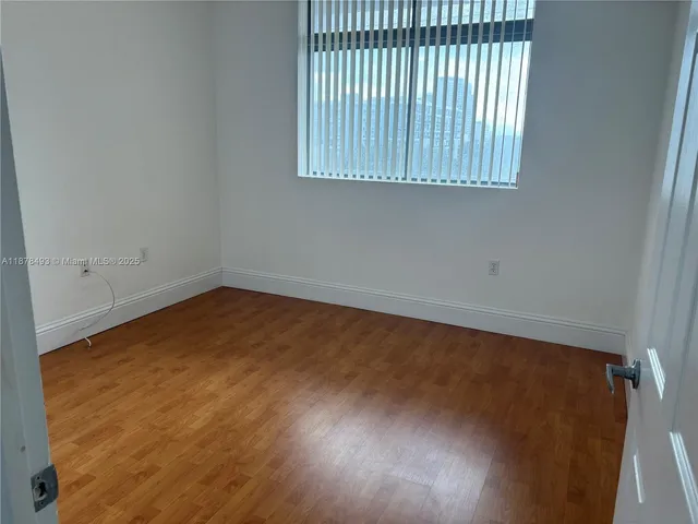 a view of a room with wooden floor and a window